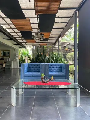 a living room with a blue couch and a table at Hotel Aromax del Campestre in Medellín