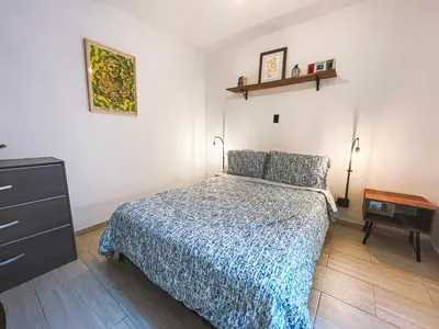 a bedroom with a bed and a dresser in it at ADN Algo de Nosotros - Malaika in Medellín