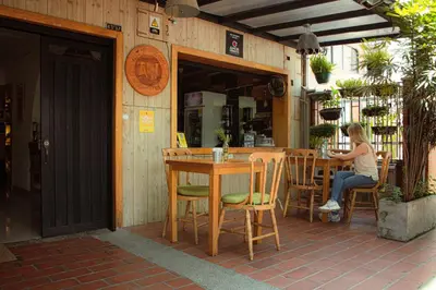 a woman sitting at a table outside of a restaurant at ADN Algo de Nosotros - Malaika in Medellín