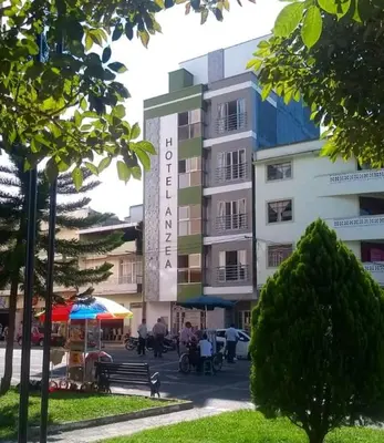 a building with a sign for the hotel at Hotel Anzea in Anserma
