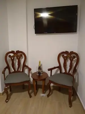 two chairs and a table with a tv on a wall at Hotel Anzea in Anserma