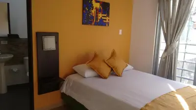 a bedroom with a bed with yellow walls and a window at Hotel Anzea in Anserma
