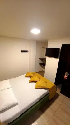 a bedroom with a bed with a yellow blanket on it at Hotel Anzea in Anserma