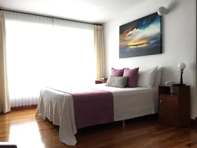 a bedroom with a bed and a large window at Regine's Manizales By Hoteles Confort 80 in Manizales