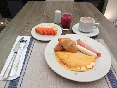a table with two plates of food and a cup of coffee at Regine's Manizales By Hoteles Confort 80 in Manizales