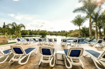 a group of chairs and a table and a lake at Hotel Los Recuerdos in Guatapé