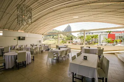 a restaurant with tables and chairs and a large window at Hotel Los Recuerdos in Guatapé