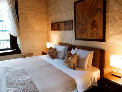 a bedroom with a large white bed with two pillows at HOTEL LA POSADA DEL ZAGUÁN in El Retiro