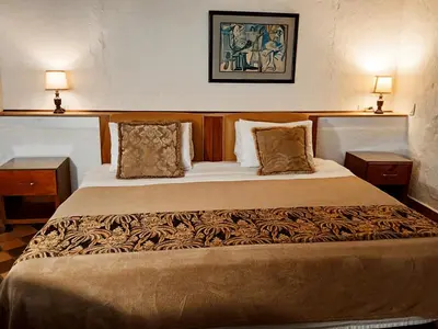 a bedroom with a large bed with two night stands at HOTEL LA POSADA DEL ZAGUÁN in El Retiro