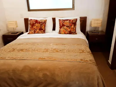 a bedroom with a bed with two lamps on it at HOTEL LA POSADA DEL ZAGUÁN in El Retiro