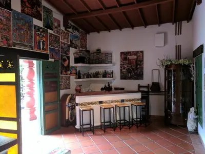 a kitchen with a bar with stools and posters on the wall at Casa Finca Paititi in San Antonio de Pereira