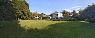 a large yard with a white house and trees at Casa Finca Paititi in San Antonio de Pereira