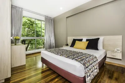 a bedroom with a large bed and a window at Hotel Asturias Medellin in Medellín