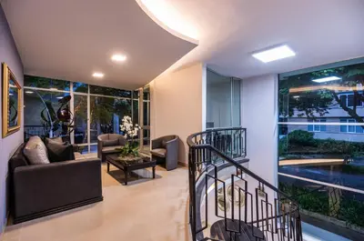 a living room filled with furniture and a large window at Hotel Asturias Medellin in Medellín