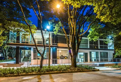 an office building at night with trees in the foreground at Hotel Asturias Medellin in Medellín