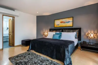 a bedroom with a large bed with blue pillows at Hotel Egina Medellin in Medellín
