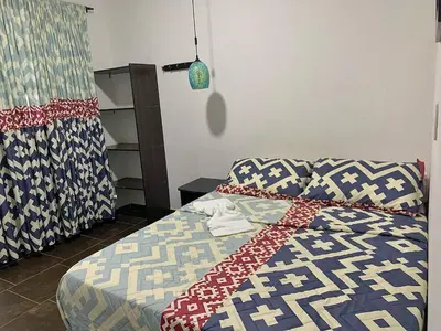 a bedroom with a bed with a blue and white quilt at Balcones de la Casona in Guatapé