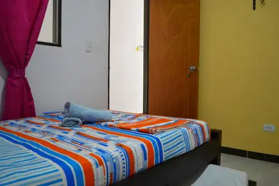 a bed with a stuffed animal sitting on top of it at Balcones de la Casona in Guatapé