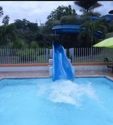 a blue water slide in a swimming pool at Cabaña Ciudadela Premium San Jeronimo in San Jerónimo