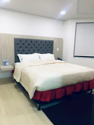 a large bed in a room with a projection screen at Hotel San Antonio Guarne in Guarne