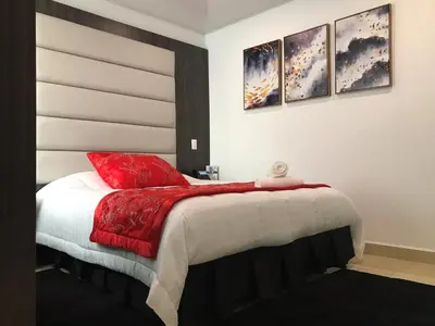 a bedroom with a bed with red pillows on it at Hotel San Antonio Guarne in Guarne