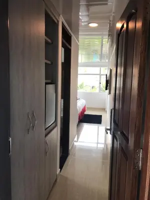 a hallway with a door and a room with a bed at Hotel San Antonio Guarne in Guarne