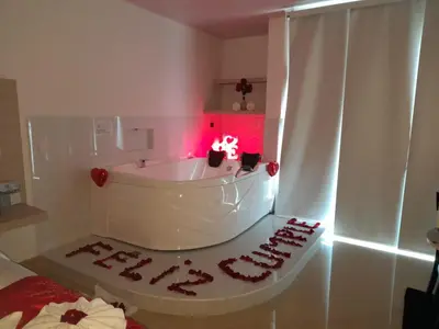 a room with a white tub with red lights at Hotel San Antonio Guarne in Guarne