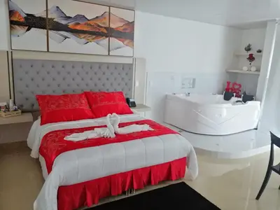 a bedroom with a red and white bed and a sink at Hotel San Antonio Guarne in Guarne