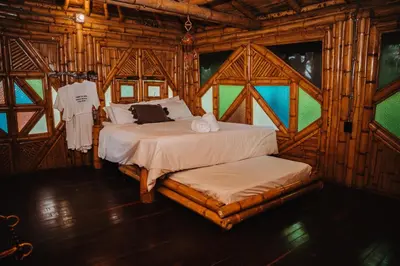 a bedroom with two beds in a wooden cabin at Ecohotel Tierra de Agua in Cocorná