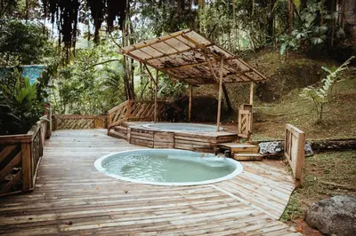 a hot tub on a wooden deck with a wooden structure at Ecohotel Tierra de Agua in Cocorná