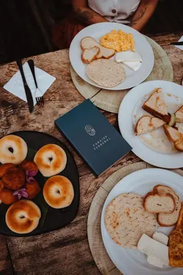 a table with plates of food and a book at Ecohotel Tierra de Agua in Cocorná