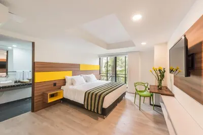 a bedroom with a bed and a desk and a sink at Foresta Hotel in Medellín