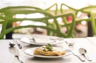 two plates of food on a table with forks and spoons at Foresta Hotel in Medellín
