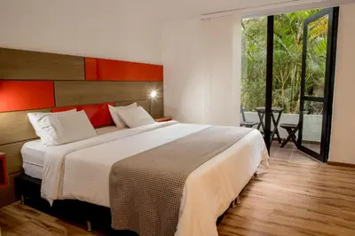 a bedroom with a large bed and a large window at Foresta Hotel in Medellín