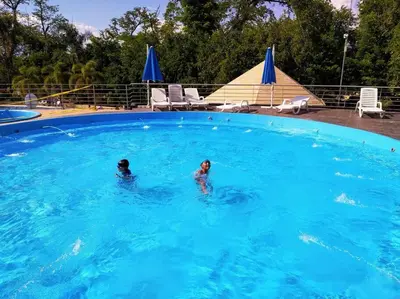 two people swimming in a large swimming pool at Condominio Terrazas del Sol in Sopetran