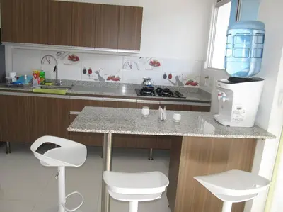 a kitchen with a counter and two stools and a counter top at Condominio Terrazas del Sol in Sopetran