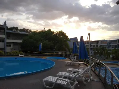 a swimming pool with lawn chairs and umbrellas on a resort at Condominio Terrazas del Sol in Sopetran