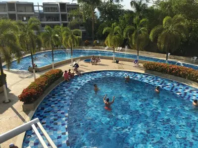 a large blue swimming pool with people in it at Condominio Terrazas del Sol in Sopetran