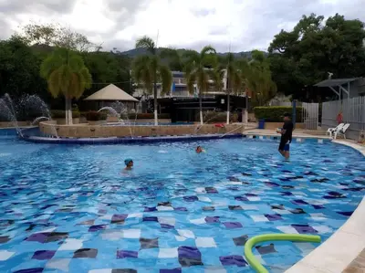 a group of people swimming in a swimming pool at Condominio Terrazas del Sol in Sopetran