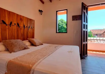 a large bed in a room with a window at Hotel Santa Barbara Colonial - Santa Fe de Antioquia in Santa Fe de Antioquia