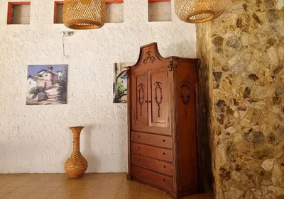 a large wooden cabinet in a room with a vase at Hotel Santa Barbara Colonial - Santa Fe de Antioquia in Santa Fe de Antioquia