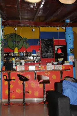a bar in a restaurant with stools and a counter at Arcadia Hostel Medellin in Medellín