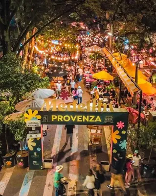 a crowd of people walking on a street at night at Hotel Provenza Garden in Medellín