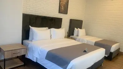 two beds in a hotel room with at Hotel Provenza Garden in Medellín