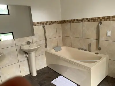 a bathroom with a bath tub and a sink at Hotel Provenza Garden in Medellín