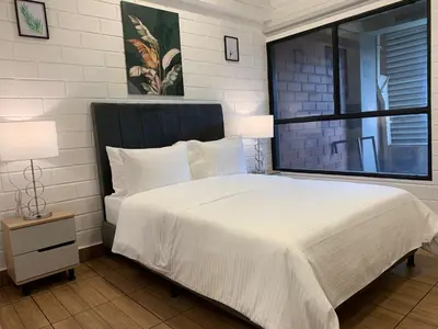 a bedroom with a large white bed with a window at Hotel Provenza Garden in Medellín