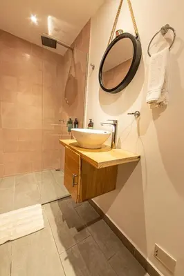 a bathroom with a sink and a mirror and a shower at La Martina Boutique Hotel in Medellín