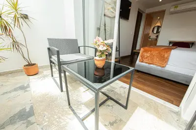 a glass table with a vase of flowers on it in a living room at La Martina Boutique Hotel in Medellín