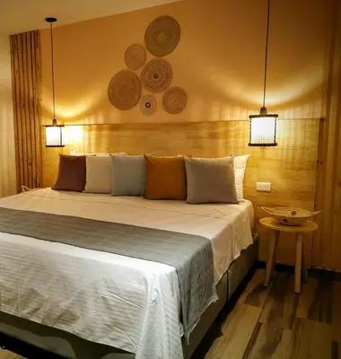 a bedroom with a large bed with two lights at La Martina Boutique Hotel in Medellín