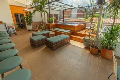 a room with a patio with benches and plants at La Martina Boutique Hotel in Medellín